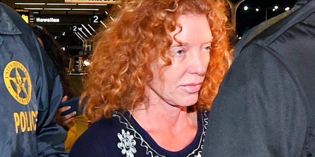 Tonya Couch, center, is taken by authorities to a waiting car after arriving at Los Angeles International Airport, Thursday, Dec. 31, 2015, in Los Angeles. Authorities said she and her son, Texas teenager Ethan Couch, who was sentenced to probation after using an "affluenza" defense for a 2013 wreck in Texas, fled to Mexico together in November as prosecutors investigated whether he had violated his probation. Both were taken into custody Monday, Dec. 28, after authorities said a phone call for pizza led to their capture in the resort city of Puerto Vallarta. (AP Photo/Mark J. Terrill)