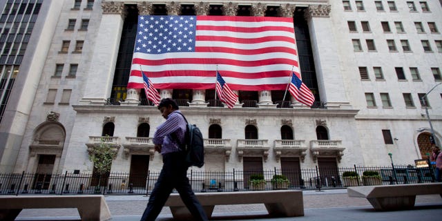 File: In this Aug. 5, 2011, photo a pedestrian walks past the New York Stock Exchange in New York.