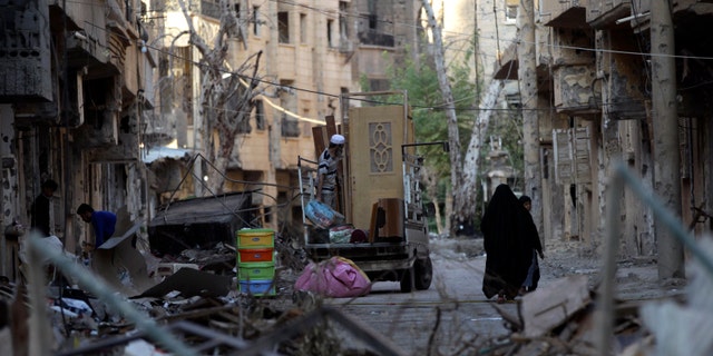 A family moves remnants of their house after it was damaged due to shelling in Deir al zor, Syria October 5, 2013. Now, at least 20 people are suspected of having contracted polio in this war-torn region of the country. (REUTERS/Khalil Ashawi)