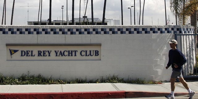FILE 2011: A man jogs past the Del Rey Yacht Club where Jean and Scott Adams, two of the four Americans killed by Somali pirates, were members in Marina Del Rey, Calif.
