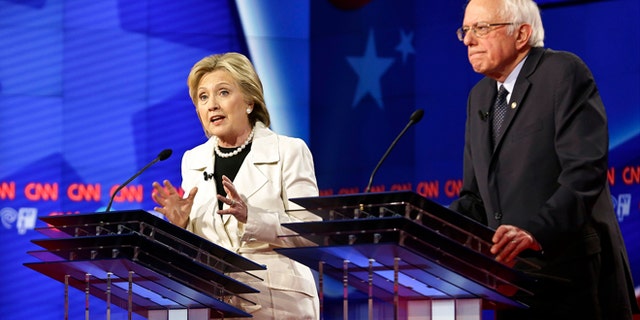 Democratic presidential candidates Sen. Bernie Sanders, I-Vt., right, listens as Hillary Clinton speaks during the CNN Democratic Presidential Primary Debate at the Brooklyn Navy Yard Thursday, April 14, 2016, New York. (AP Photo/Seth Wenig)