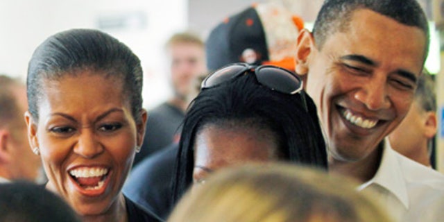 FILE - In this Friday, April 23, 2010 file photo, first lady Michelle Obama and President Barack Obama wait in line to order at 12 Bones Smokehouse in Asheville, N.C. Everyone likes to be praised, but when First Lady Michelle Obama listed "great barbecue" as one of Charlotte's virtues, it was a bit much even for people thrilled that North Carolina's largest city will host next year's Democratic national convention.(AP Photo/Alex Brandon)