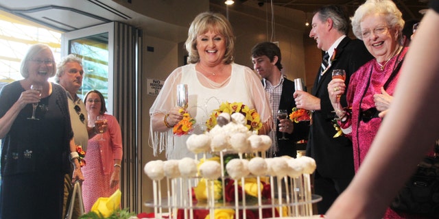 Nancy Levindowski reacts as her wedding cake is wheeled out after exchanging vows with Steve Keller at the Denny's restaurant.