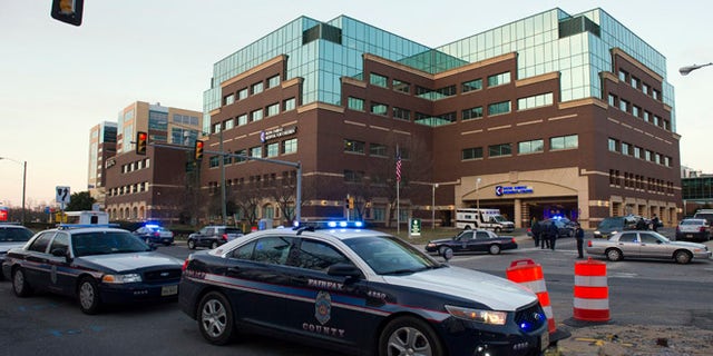FILE - In this March 31, 2015 file photo, Fairfax County, Va. Police stand guard at Inova Fairfax Hospital Center in Falls Church, Va. A sheriffÃ¢â¬â¢s deputy fatally shot a man who threatened him with an unidentified object outside a northern Virginia hospital, authorities said Tuesday, Aug. 16, 2016. Inova Fairfax Hospital security called county public safety communications to report a suspicious man with an edged weapon at a bus stop on the hospitalÃ¢â¬â¢s campus on Monday night, Fairfax County Police said in a statement.  (AP Photo/Cliff Owen, File)