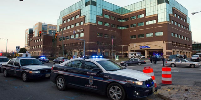 FILE - In this March 31, 2015 file photo, Fairfax County, Va. Police stand guard at Inova Fairfax Hospital Center in Falls Church, Va. A sheriffââ¬â¢s deputy fatally shot a man who threatened him with an unidentified object outside a northern Virginia hospital, authorities said Tuesday, Aug. 16, 2016. Inova Fairfax Hospital security called county public safety communications to report a suspicious man with an edged weapon at a bus stop on the hospitalââ¬â¢s campus on Monday night, Fairfax County Police said in a statement. (AP Photo/Cliff Owen, File)