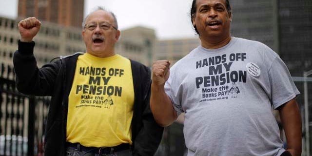 FILE - In a Thursday, July 3, 2014 file photo, Detroit retirees Mike Shane, left, and William Davis protest near the federal courthouse in Detroit. (AP Photo/Paul Sancya, File)