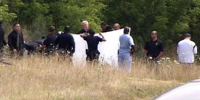 Detroit police block a road near where sources say two bodies were discovered Friday morning.