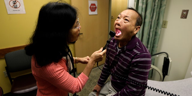 FILE - In this Friday, March 1, 2013 file photo, Chan Lai Ly, right, has his mouth examined by Honghue Duong, a physician's assistant, as part of a regular check-up related to his diabetes at International Community Health Services in Seattle. Over the last two decades, the rates of heart attacks and strokes among diabetics fell by more than 60 percent, a new federal study shows. The research from the Centers for Disease Control and Prevention was reported in the Thursday, April 17, 2014 edition of the New England Journal of Medicine. The drop is mainly attributed to better screening, medicines and care. The improvements came even as the number of U.S. adults with diabetes more than tripled in those 20 years. (AP Photo/Ted S. Warren)