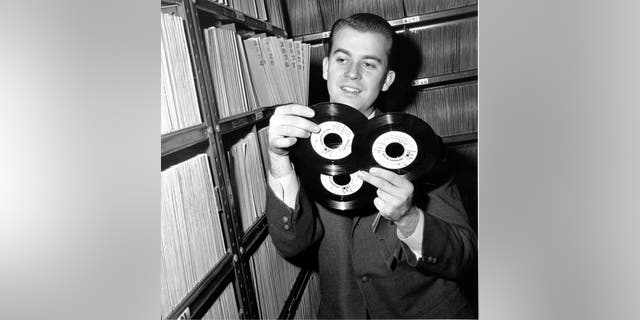 In this Feb. 3, 1959, file photo, Dick Clark selects a record in his station library in Philadelphia. Clark, the television host who helped bring rock ‘n’ roll into the mainstream, died on April 18, 2012, of a heart attack at 82.