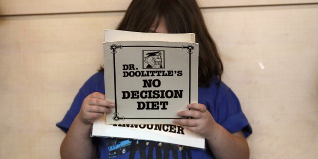 An overweight child reads her part in a humorous skit held during a program for overweight adolescents in Colorado.