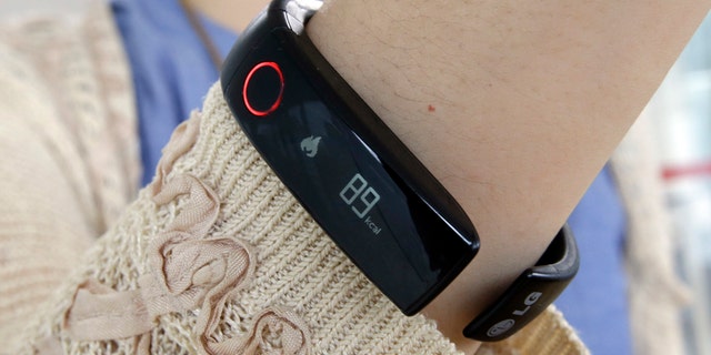 In this June 5, 2014 photo, a reporter shows LGs Lifeband Touch for photographs in Seoul, South Korea.