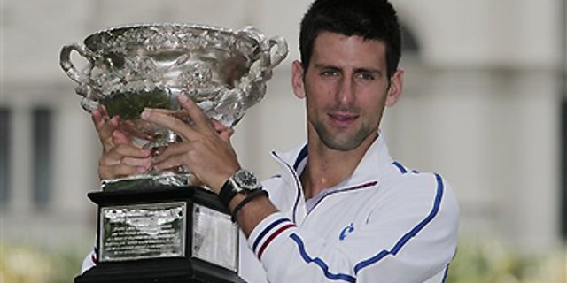 Jan. 30, 2012: Australian Open men's singles champion Serbia's Novak Djokovic poses with his trophy at a park in central Melbourne, Australia. Djokovic defeated Spain's Rafael Nadal in five hours and 53 minutes to win a third Australian Open title earlier in the day.
