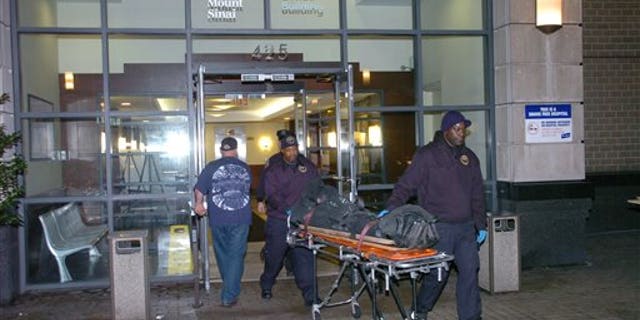 The body of Dmitriy Kanarikov, 35, is removed from 425 west 59th street, Sunday, Dec. 22, 2013, in New York.