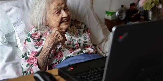 Patient Louise Irving watches a laptop computer with her daughter's morning wake-up video playing, at The Hebrew Home of Riverdale, in New York.