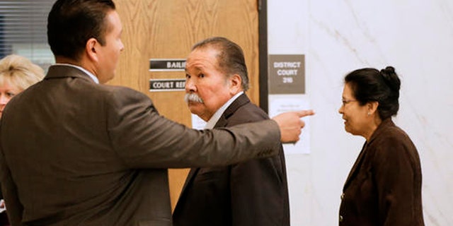 Frederick and Estella Garcia, along with their son Fernando, left, arrive to the Douglas County Courtroom in Omaha, Neb., Monday, Oct. 3, 2016, as lawyers gave opening statements in the first-degree murder trial of their son Anthony Garcia, charged in the killings of four people with ties to Creighton University's medical school. (AP Photo/Nati Harnik)