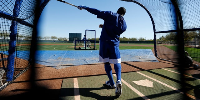 Los Angeles Dodgers' Yasiel Puig points out his shot after hitting a ball during a spring training baseball workout Wednesday, Feb. 25, 2015, in Phoenix. (AP Photo/John Locher)