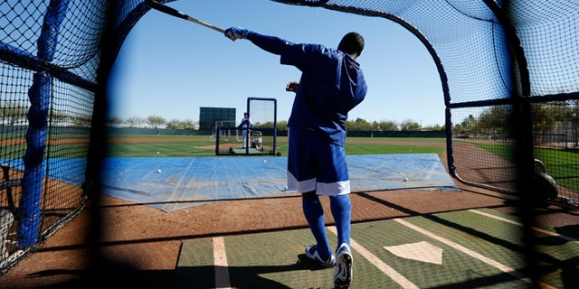 Los Angeles Dodgers' Yasiel Puig points out his shot after hitting a ball during a spring training baseball workout Wednesday, Feb. 25, 2015, in Phoenix. (AP Photo/John Locher)