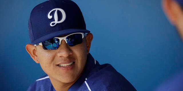 FILE - In this March 14, 2016, Los Angeles Dodgers pitcher Julio Urias smiles while talking to teammates in the dugout during a spring training baseball game against the Milwaukee Urias, 19, is set to make his highly anticipated major league debut for the Dodgers on Friday night, May 27, 2016, in New York against the Mets (AP Photo/Jae C. Hong, File)