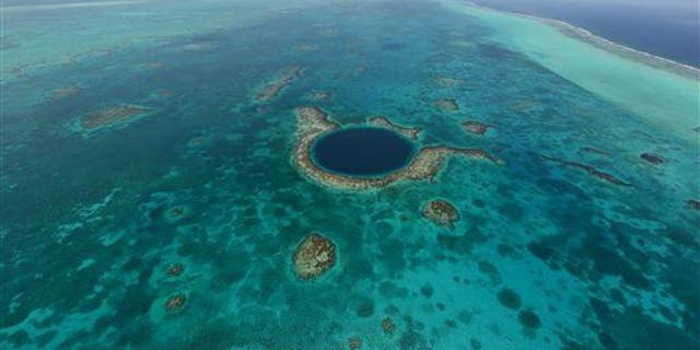 This undated image provided by the Belize Tourist Board shows an aerial view of the Great Blue Hole, a popular diving site that's part of Belize's barrier reef.