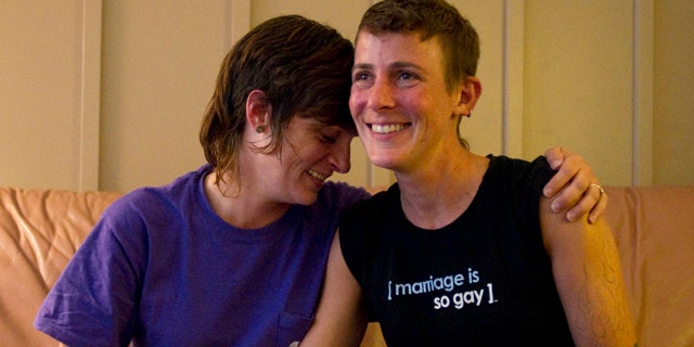 July 25: Lesbian couple Jennifer Tipton, left, and Olivier Odom are seen at a coffee house in Knoxville, Tenn. The couple are calling for Dollywood Splash County to be more inclusive to its guests after they were asked to reverse the pro-gay marriage T-shirt worn by Odom, during a recent visit.