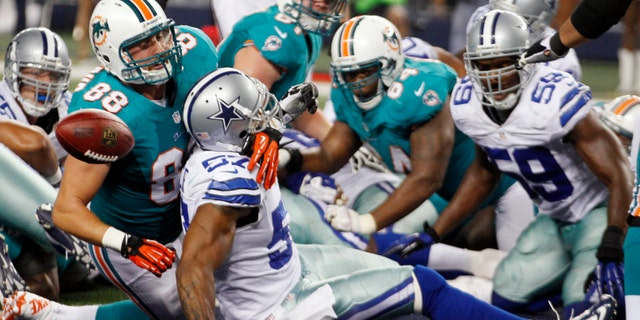 Aug. 29, 2012: Miami Dolphins tight end Jeron Mastrud (88) tangles with Dallas Cowboys linebacker Victor Butler (57) as the ball pops loose after a touchdown scored by Dolphins' Lamar Miller (not shown) during the third quarter of the NFL preseason football game, in Arlington, Texas.
