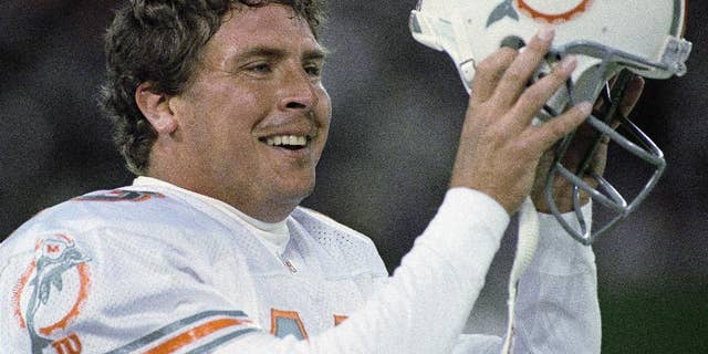 FILE - In this Nov. 27, 1994, file photo, Miami Dolphins quarterback Dan Marino removes his helmet after throwing the winning touchdown against the New York Jets during fourth-quarter action of an NFL football game in East Rutherford, N.J. It is almost 20 years to the day since the Jets led 24-21 with 30 seconds left and the Dolphins had the ball at the New York 8. (AP Photo/Eric Miller, File)
