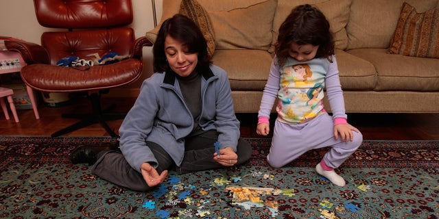 NEW YORK - DECEMBER 11:  Jocelyn Taub, a job-hunting marketing professional, works on a puzzle with a three-year-old girl while babysitting for extra money December 11, 2008 in New York City.  Taub has worked in the music promotion and radio business her whole career, but was let go from her job 10 months ago and has been job searching ever since.  To make ends meet, she's been working odd jobs in offices for friends and is doing some babysitting. "I've seen downturns before, but it's never been like this," she says.  (Photo by Chris Hondros/Getty Images)