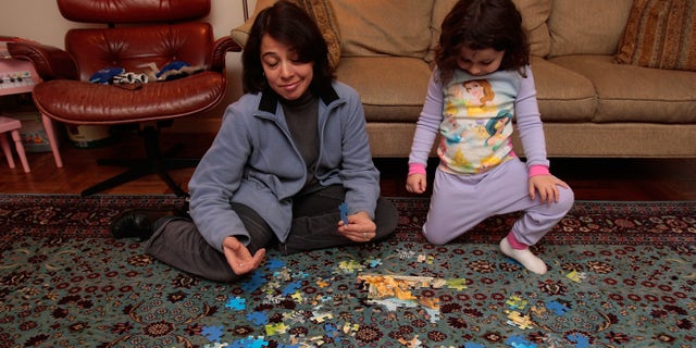 NEW YORK - DECEMBER 11: Jocelyn Taub, a job-hunting marketing professional, works on a puzzle with a three-year-old girl while babysitting for extra money December 11, 2008 in New York City. Taub has worked in the music promotion and radio business her whole career, but was let go from her job 10 months ago and has been job searching ever since. To make ends meet, she's been working odd jobs in offices for friends and is doing some babysitting. "I've seen downturns before, but it's never been like this," she says. (Photo by Chris Hondros/Getty Images)