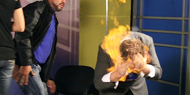 Nov. 26, 2012: In this picture released by American magician Wayne Houchin, Dominican TV presenter Franklin Barazarte, left, watches as Houchin's head burns while taping "Closer To The Stars" TV program in Santo Domingo, Dominican Republic.