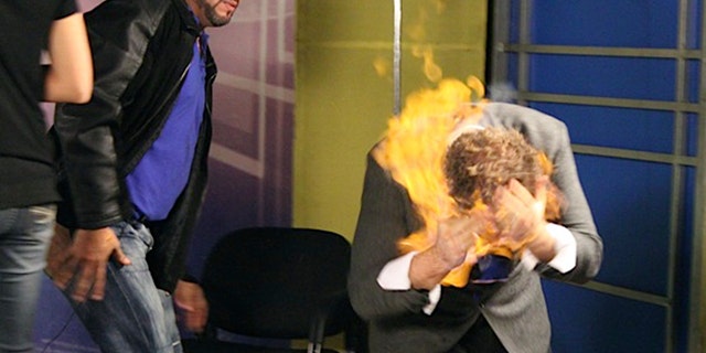 Nov. 26, 2012: In this picture released by American magician Wayne Houchin, Dominican TV presenter Franklin Barazarte, left, watches as Houchin's head burns while taping "Closer To The Stars" TV program in Santo Domingo, Dominican Republic.