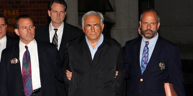 Dominique Strauss-Kahn (C), head of the International Monetary Fund (IMF), departs a New York Police Department precinct in New York late May 15, 2011.  A handcuffed IMF chief, Dominique Strauss-Kahn, facing charges he sexually assaulted a hotel maid, was escorted from a New York Police Department unit late on Sunday.   REUTERS/Mike Segar (UNITED STATES - Tags: CRIME LAW BUSINESS IMAGES OF THE DAY)