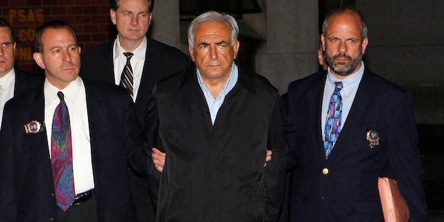 Dominique Strauss-Kahn (C), head of the International Monetary Fund (IMF), departs a New York Police Department precinct in New York late May 15, 2011. A handcuffed IMF chief, Dominique Strauss-Kahn, facing charges he sexually assaulted a hotel maid, was escorted from a New York Police Department unit late on Sunday. REUTERS/Mike Segar (UNITED STATES - Tags: CRIME LAW BUSINESS IMAGES OF THE DAY)