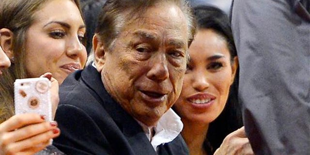 Donald Sterling and V. Stiviano, right, watch the Clippers play the Sacramento Kings on Friday, Oct. 25, 2013.
