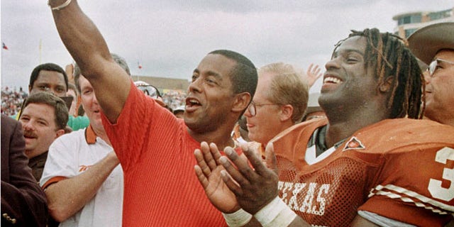 FILE: University of Texas Longhorns Ricky Williams, right, laughs as former Dallas Cowboys star Tony Dorsett signals 'Hook 'em horn' after Williams surpassed Dorsett's NCAA rushing record.