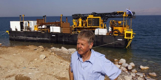Zvi Ben-Avraham, head of the drilling project, stands in front of a moored drilling platform on the shore of the Dead Sea, near Kibbutz Ein Gedi November 16, 2010. A group of engineers and scientists will analyze 500,000 years of geological history, deciphering patterns and using them to find the best way to manage the earth's resources and environment.