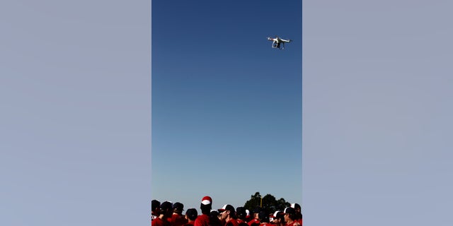 FILE - A remote controlled model aircraft flies over the Washington Nationals spring training baseball workout in Viera, Fla.