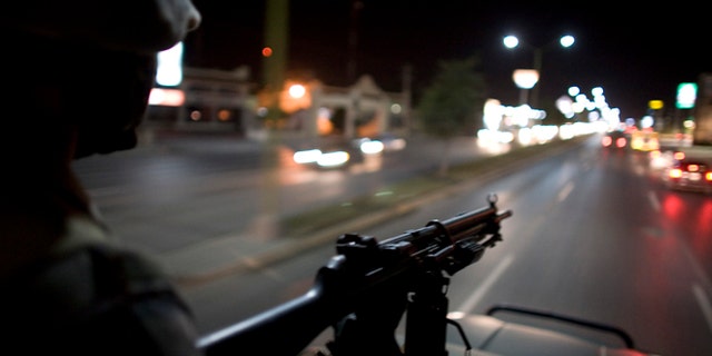 FILE - In this March 17, 2009 file photo, Mexican soldiers patrol the streets of Reynosa, on Mexico's northeastern border with the United States. On March 10, 2013, heavy gunfire echoed along the main thoroughfare and across several neighborhoods in a firefight that lasted for hours, leaving perforated and burned vehicles scattered across the border city. Social media exploded with reports of dozens dead. Witnesses saw at least 12, but an official count showed only a couple of deaths. (AP Photo/Alexandre Meneghini, File)