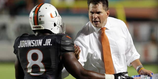 Miami Hurricanes head coach Al Golden, right, congratulates Duke Johnson (8) for scoring a touchdown against Duke in the first half of an NCAA college football game in Miami Gardens, Fla., Saturday, Sept. 27, 2014. (AP Photo/Alan Diaz)