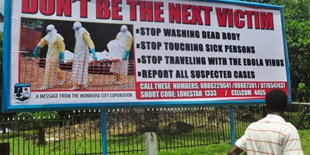 A man walks past a billboard warning people of the deadly Ebola virus in Monrovia, Liberia. Friday, Oct. 10, 2014. The number of people killed in the Ebola outbreak has risen above 4,000, the World Health Organization has said. The latest figures show there have been 8,376 cases and 4,024 deaths in the worst-affected West African nations of Guinea, Liberia and Sierra Leone. The news comes as Liberian MPs refused to grant the president additional powers to deal with the Ebola crisis. (AP Photo/ Abbas Dulleh)
