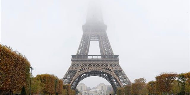 Fog and smog swallow up the top of the Eiffel Tower in Paris Monday, Nov. 2, 2015. Paris authorities have put in place measures to limit traffic after high levels of pollution in the French capital. (AP Photo/Jacques Brinon)