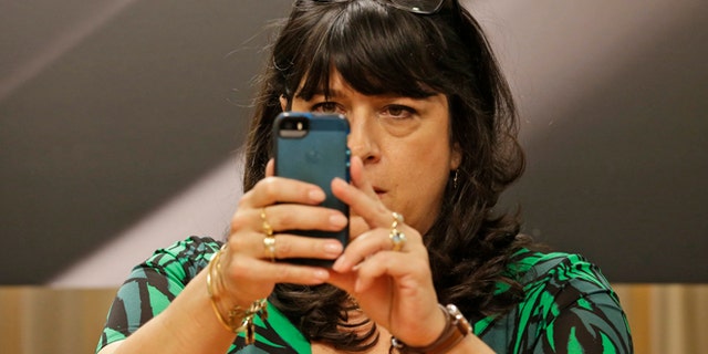 Author EL James takes a picture of photographers before signing her new book, âGrey,â at a Barnes and Noble bookstore in New York, Thursday, June 18, 2015.  (AP Photo/Mary Altaffer)