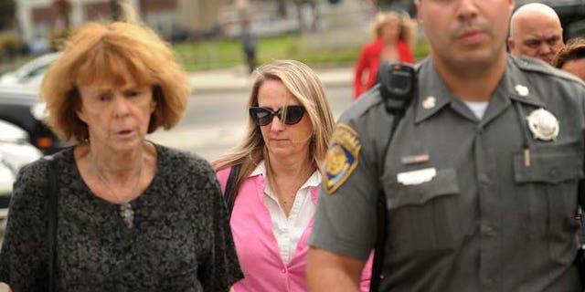 Oct. 13: Jennifer Connell, center, is escorted to her car by marshals after her lawsuit against her Westport nephew was found in his favor in Superior Court in Bridgeport, Conn.