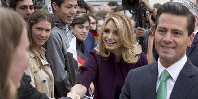 In this April 11, 2016 file photo, Mexico's President Enrique Pena Nieto, right, and his wife Angelica Rivera de Pena greet students as they arrive to meet with Germany's President Joachim Gauck at Bellevue Palace in Berlin, Germany. Pena Nieto apologized on Monday, July 18, 2016 for a 2014 scandal involving a mansion his wife bought from a firm that won lucrative contracts with his administration. (AP Photo/Michael Sohn, File)
