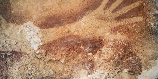 This undated handout photo provided by Nature Magazine shows stencils of hands in a cave in Indonesia. Ancient cave drawings in Indonesia are as old as famous prehistoric art in Europe, according to a new study. (AP Photo/Kinez Riza, Nature Magazine)