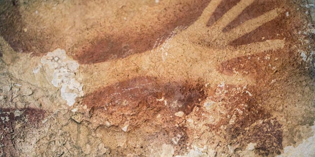This undated handout photo provided by Nature Magazine shows stencils of hands in a cave in Indonesia. Ancient cave drawings in Indonesia are as old as famous prehistoric art in Europe, according to a new study. (AP Photo/Kinez Riza, Nature Magazine)