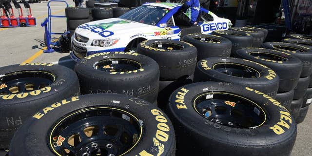 In this Feb. 14, 2015 photo, Goodyear tires surround the Casey Mears car in the garage area during a practice session for the Daytona 500 NASCAR Sprint Cup Series auto race at Daytona International Speedway, in Daytona Beach, Fla. The Goodyear Tire & Rubber Co. reports quarterly financial results on Tuesday, Feb. 17, 2015. (AP Photo/Phelan M. Ebenhack)