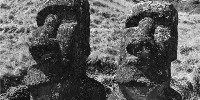 Circa 1955: Two ancient statues of uncertain origin on Easter Island, in the South Pacific Ocean.