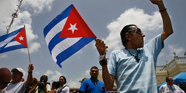 MIAMI - AUGUST 1: Angel Febles (R) of Miami Beach, Florida, waves a Cuban flag and shouts "Viva Cuba libre" in front of Versallies Restaurant in the Little Havana neighborhood August 1, 2006 in Miami, Florida. Febles immigrated to the U.S. from Cuba in 1960. Cuban Americans were celebrating the news that Fidel Castro had turned over power to his younger brother, Raul Castro, while he undergoes medical treatment for intestinal bleeding. (Photo by Chip Somodevilla/Getty Images)