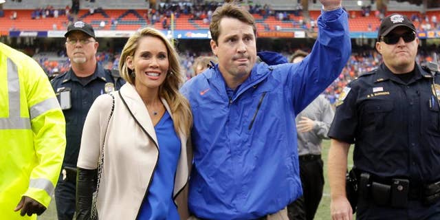 Florida head coach Will Muschamp, right, waves to cheering fans as he leaves the field with his wife Carol after an NCAA college football game against Eastern Kentucky in Gainesville, Fla., Saturday, Nov. 22, 2014. Florida won 52-3. Muschamp was fired earlier this week, but will finish the season with the team. (AP Photo/John Raoux)