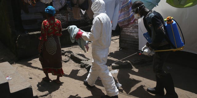MONROVIA, LIBERIA - OCTOBER 17: A health worker carries Benson, 2 months, to a re-opened Ebola holding center in the West Point neighborhood on October 17, 2014 in Monrovia, Liberia. The baby, her mother and grandmother were all taken to the center after an Ebola tracing coordinator checked their temperature and found they all had fever. A family member living in the home had died only the day before from Ebola. The West Point holding center was re-opened this week with community support, two months after a mob overran the facility and looted it's contents, many denying the presence of Ebola in their community. The World Health Organization says that more than 4,500 people have died due to the Ebola epidemic in West Africa with a 70 percent mortality rate for those infected with the virus. (Photo by John Moore/Getty Images)